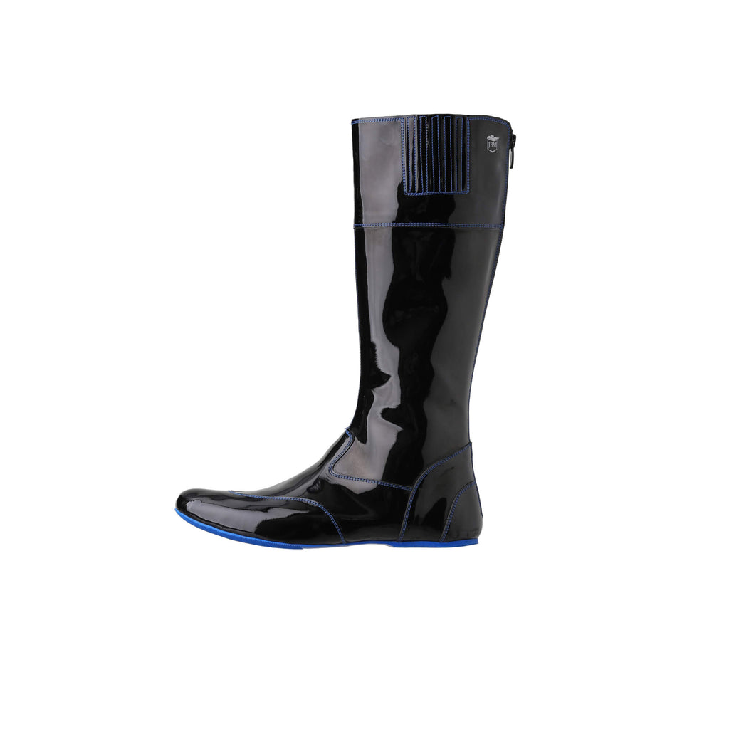 Image showing one tall racing boot against a white background. The boot is made of black material with blue exterior stitching and blue soles. It features a back zip and a 1.5-2cm stretch feature around the calf area. This image provides a side perspective of the boot.