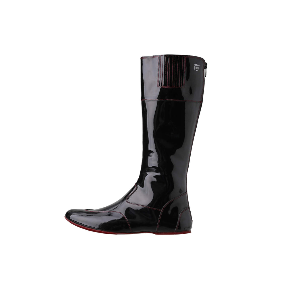 A single tall racing boot displayed against a white background. The boot is made of black material with burgundy exterior stitching and burgundy soles. It features a back zip and a 1.5-2cm stretch feature around the calf. This image showcases the boot from a side perspective.