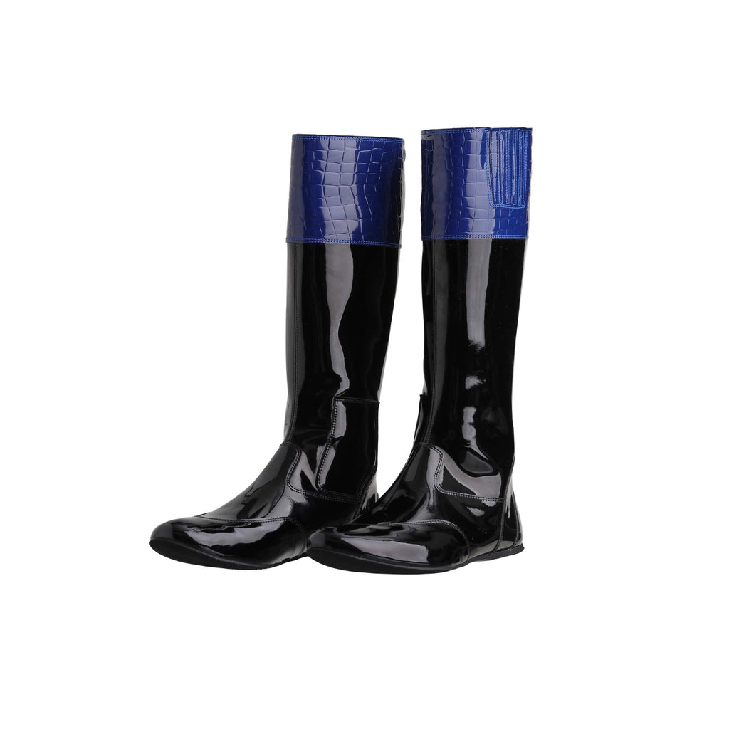 A pair of tall racing boots against a white background. The boots are made of black material with blue crocodile leather accents around the calf area. They feature a back zip and a 1.5-2cm stretch feature around the calf. The boots are crafted from light, tough, flexible, and strong material. Both shoes are positioned sole down with the zipper done, angled slightly to one side.