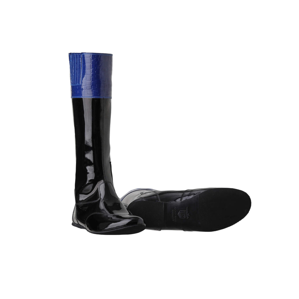 A pair of tall racing boots against a white background. The boots are made of black material with blue crocodile leather accents around the calf area. They feature a back zip and a 1.5-2cm stretch feature around the calf. The boots are crafted from light, tough, flexible, and strong material.  One boot is positioned sole down with the zipper done, while the other boot is laid down to showcase the sole design.