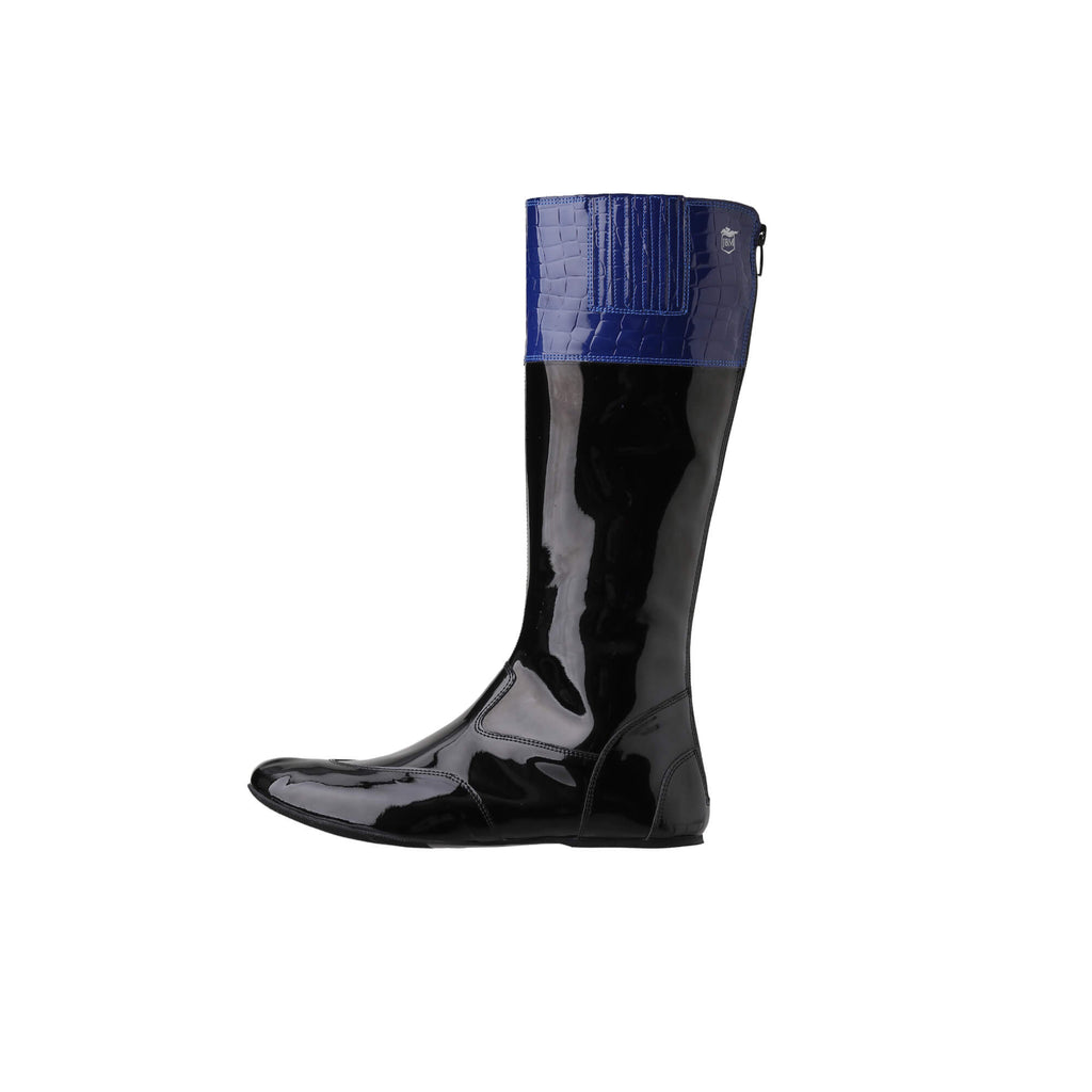 A tall racing boot against a white background. The boot is made out of black material with blue crocodile leather accents around the calf area. It features a back zip and a 1.5-2cm stretch feature around the calf. The boot is crafted from light, tough, flexible, and strong material.  This image showcases only one boot from a side perspective.