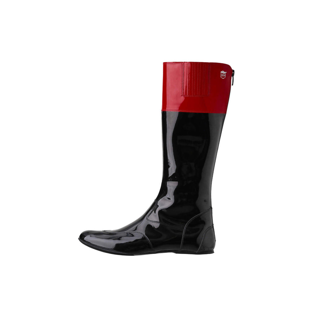 Tall racing boots with black material and red patent leather accents on the calf, displayed on a white background. The boots feature a back zip and a 1.5-2cm stretch feature on the calf area. They are made of light, flexible, and strong material. This image showcases a single boot from a side perspective.