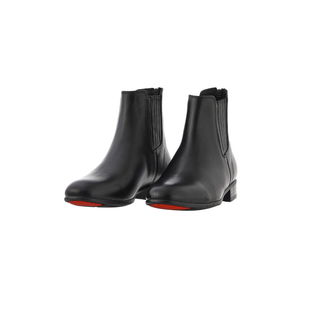 A pair of short classic black leather boots featuring a back zip, presented on a white background. The boots are showcased sole down with the zipper securely fastened, while the angle is slightly tilted to one side for an elegant display.