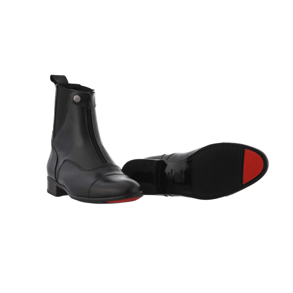 A pair of classic black boots with a front zip and buckle, showcased on a white background. One shoe is displayed sole down with the buckle and zip fastened, while the other shoe is laid down to highlight the sole, featuring a signature red tip design.