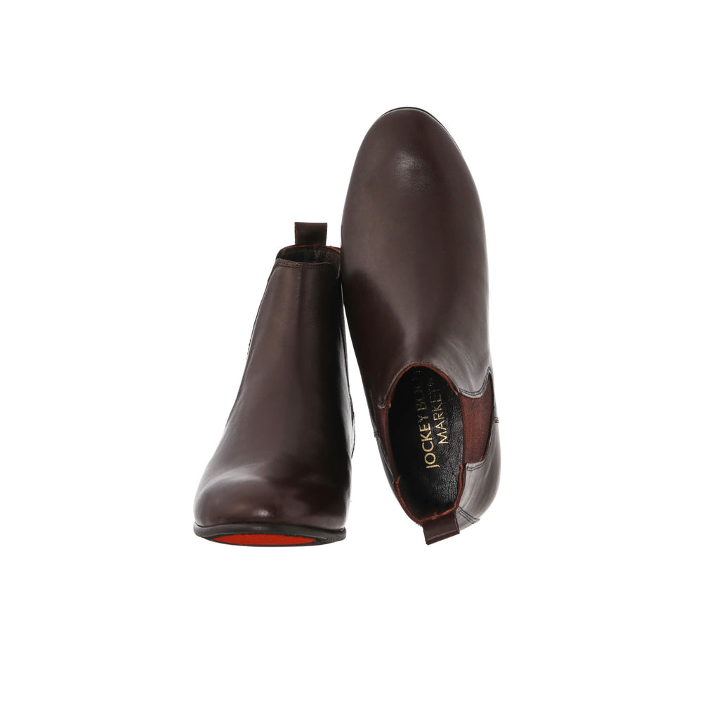 A pair of classic brown leather boots with an easy slide-in design, showcased on a white background. The first shoe's sole is resting on the floor, while the second shoe is displayed upside down to highlight the inside of the shoe.