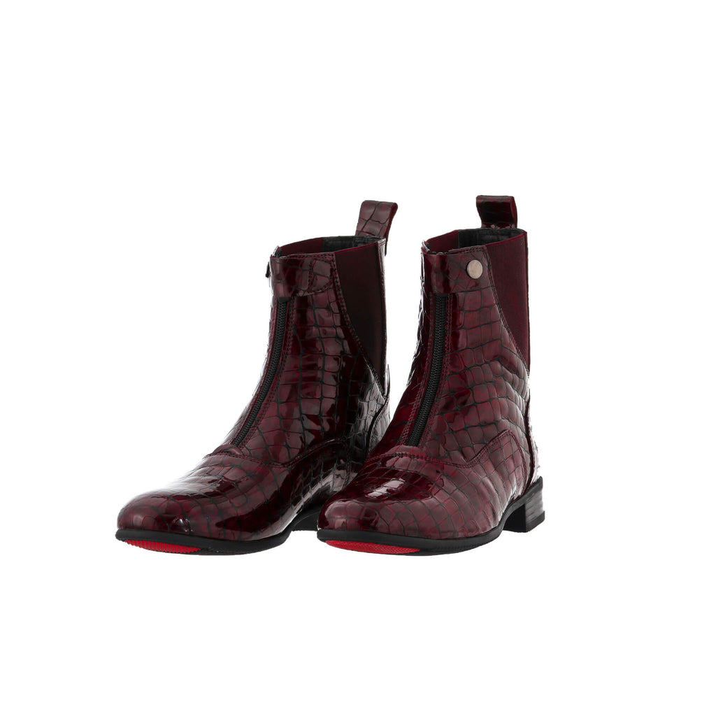 A pair of burgundy crocodile leather boots displayed against a white background. Both boots are positioned sole-down with the front zip and buckle closure completed. The angle of the display is slightly positioned to one side, offering a dynamic perspective.