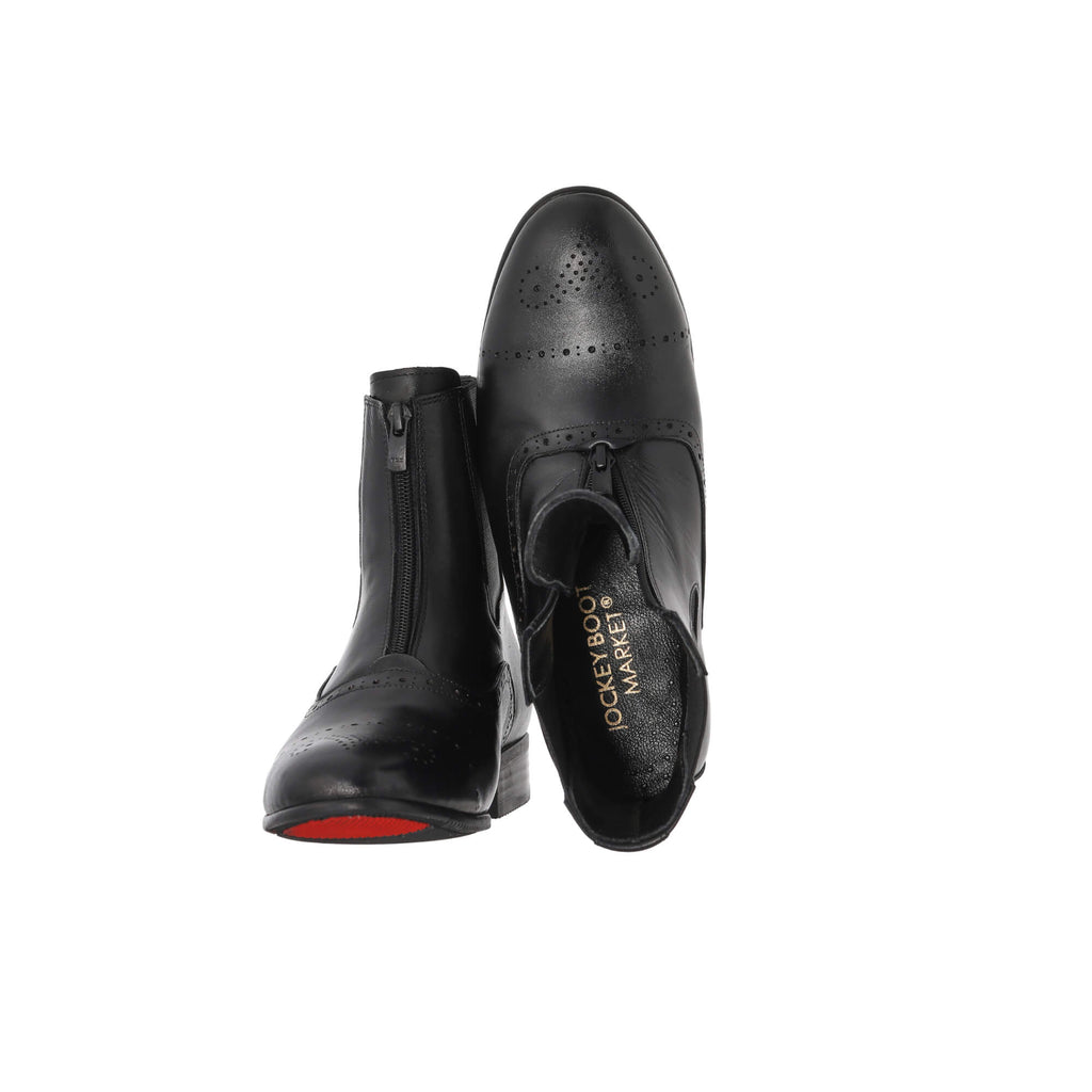 A pair of black leather wingtip-style boots with front zip and zipper overlay, set against a white background. The first shoe's sole rests on the floor with the zipper done. The second shoe is displayed upside down to reveal the interior, with the undone zipper and overlay showcased.