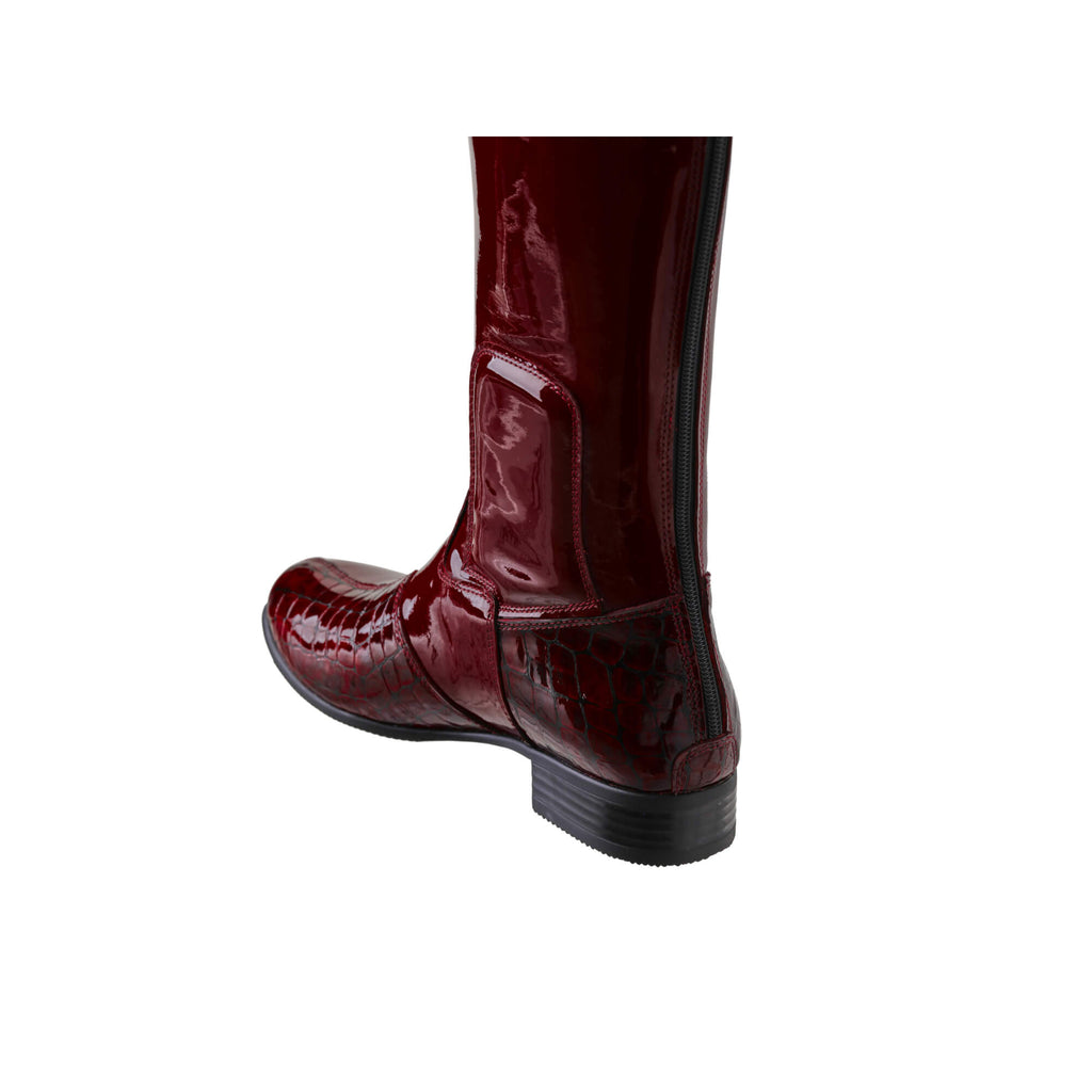 A tall burgundy patent and crocodile leather boot displayed against a white background. The boot features a back zip and a 1.5-2cm stretch feature on the calf area. This image shows only one boot from the back perspective.