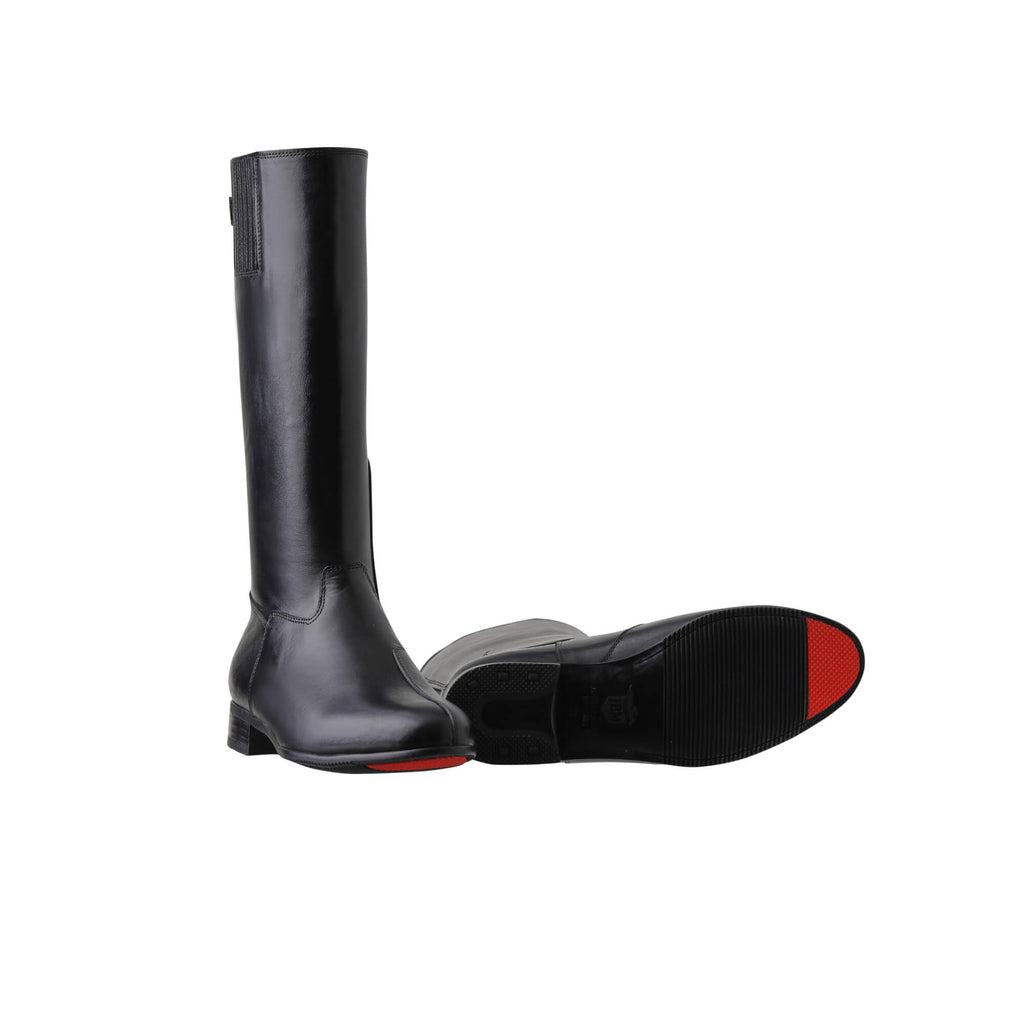 A pair of black tall leather boots featuring a back zip and a 1.5 - 2cm ability to loosen the calf area if required, displayed against a white background. The first shoe's sole is placed on the floor with the zip done. The second shoe is laid down, showcasing the sole of the boot featuring a red tip design.