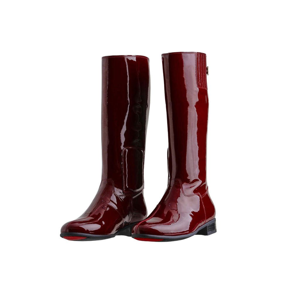 A pair of tall burgundy patent leather boots with a back zip and a 1.5-2cm stretch feature on the calf area. Displayed against a white background, both shoes are positioned sole down with the zipper done, angled slightly to one side.