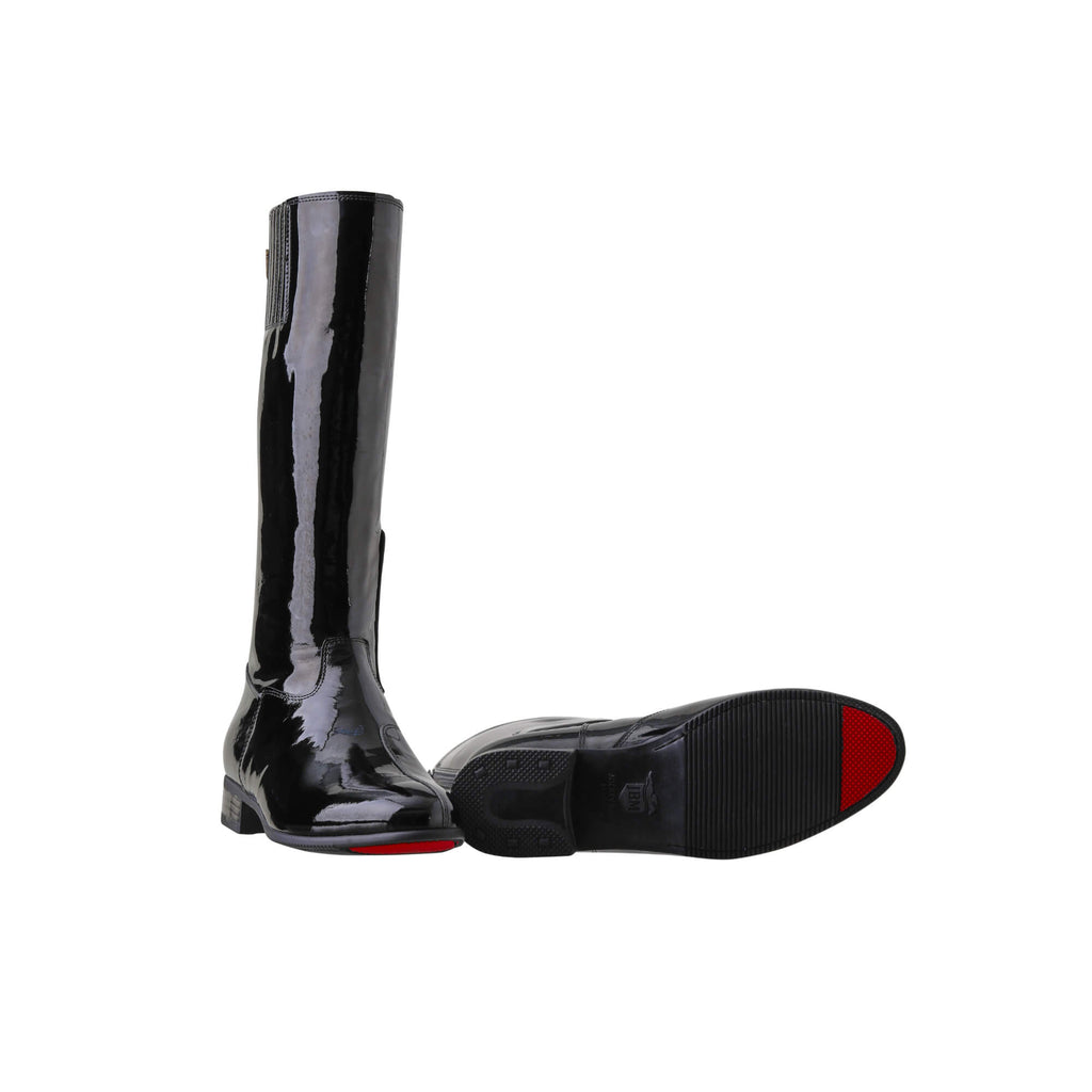 A pair of tall black patent leather boots displayed against a white background. One boot is positioned sole down with the zipper done, while the other boot is laid down to showcase its sole, featuring a red tip design and the 1.5-2cm stretch feature on the calf area.