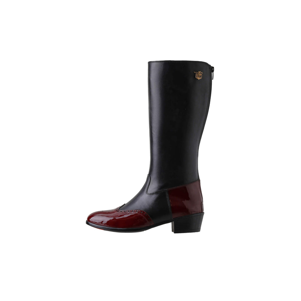 A tall black leather Cuban heel boot with burgundy wingtip accents. The boot features a back zip and is displayed against a white background. This image only showcases one boot from a side perspective.